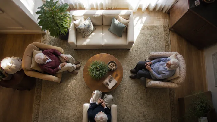 Overhead view of a living room with a couch, armchairs, and a dining table